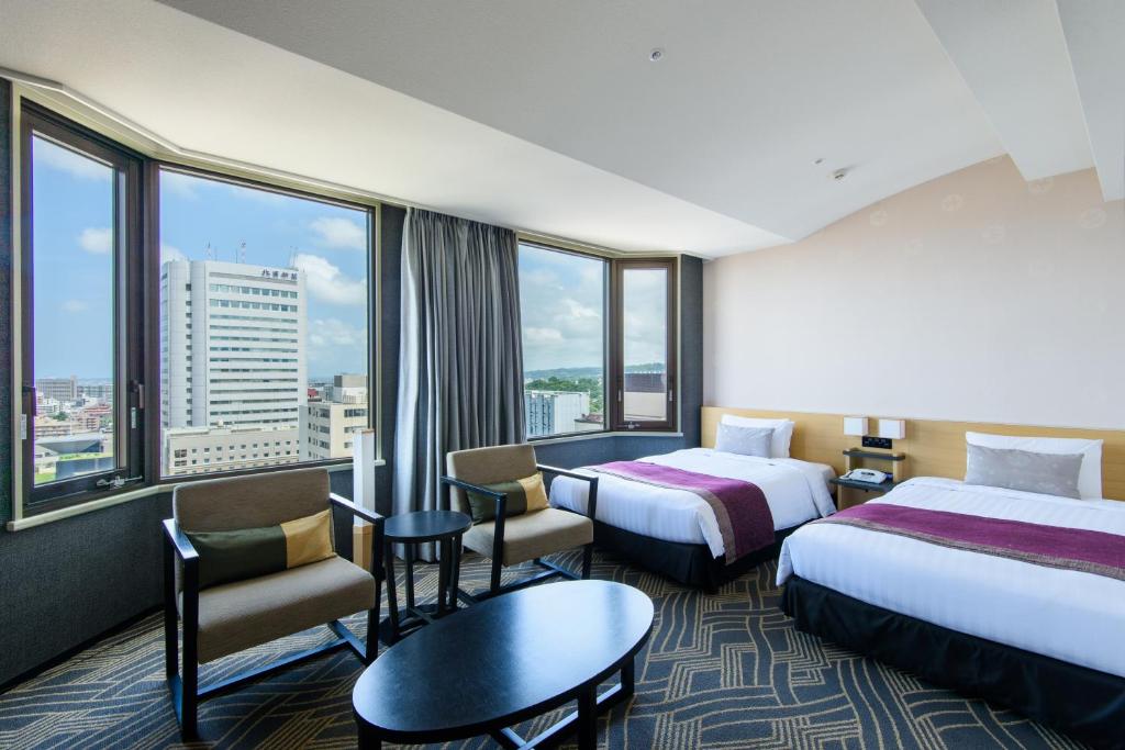 a hotel room with two beds and a large window at Kanazawa Tokyu Hotel in Kanazawa