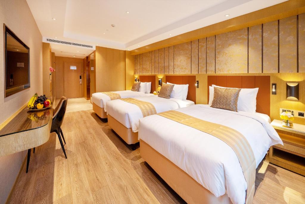 Postel nebo postele na pokoji v ubytování Grand Dragon Hotel