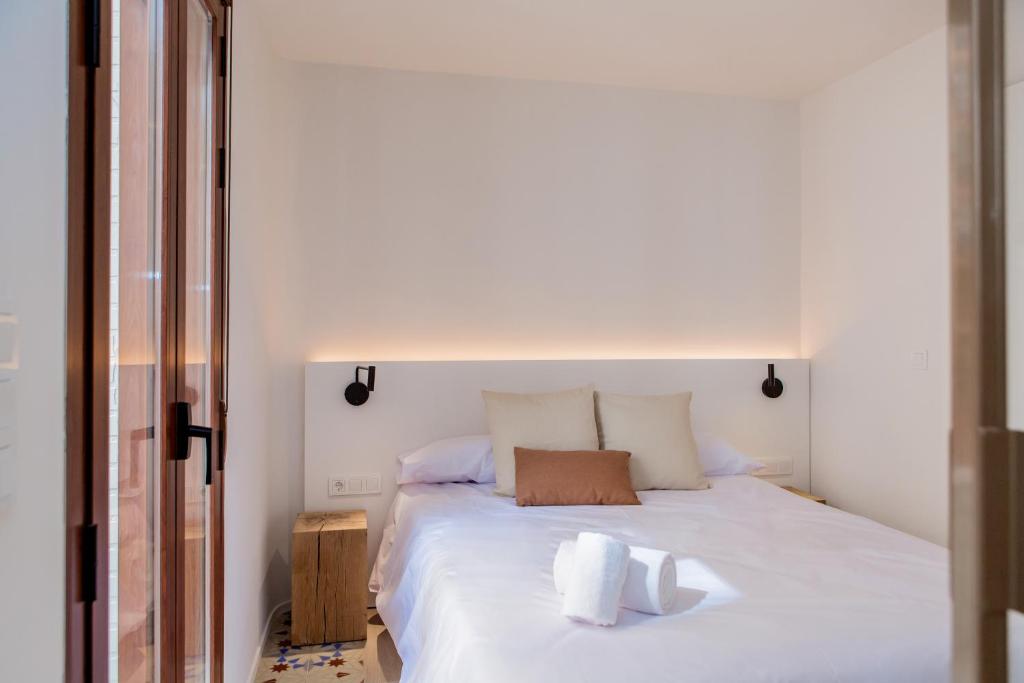 una camera da letto con un grande letto bianco con due cuscini di Pizarro by Seaward Suites a Villajoyosa