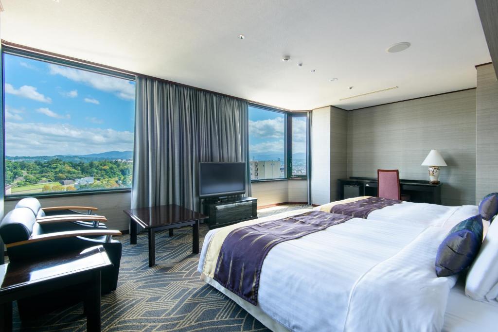 a hotel room with a bed and a large window at Kanazawa Tokyu Hotel in Kanazawa