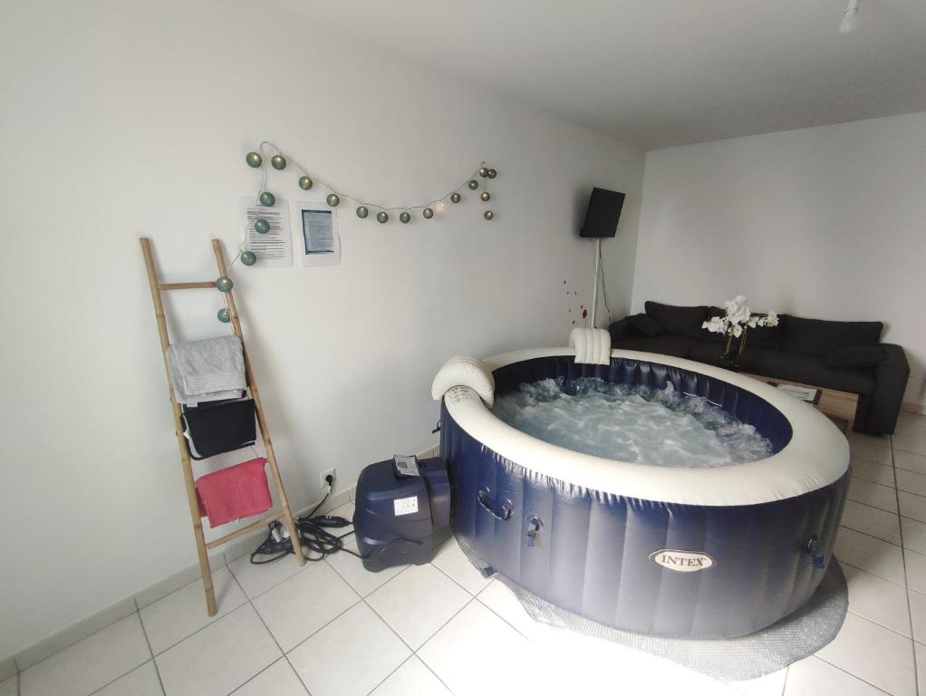 una gran bañera azul en una habitación con sofá en Le Tribord T3 étoilé avec jacuzzi, en Saint-Méloir-des-Ondes