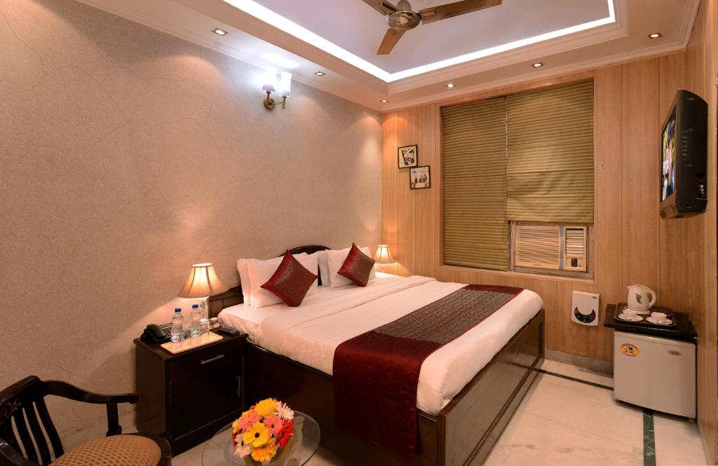 um quarto com uma cama, uma mesa e uma janela em Sands INN Hotel em Gurgaon