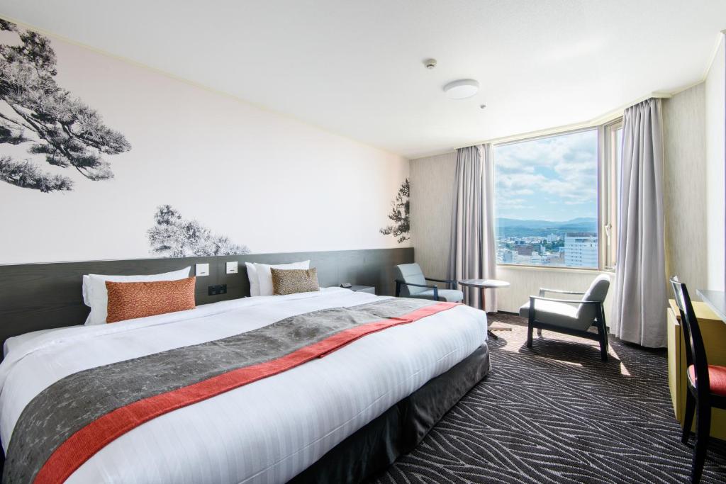 a hotel room with a bed and a large window at Kanazawa Tokyu Hotel in Kanazawa
