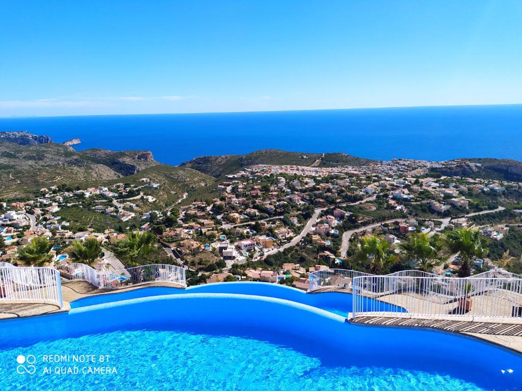 uma vista para o resort a partir da piscina de beiral infinito em Vista Divina em Cumbre del Sol