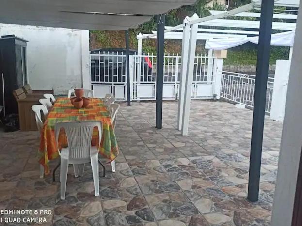 patio ze stołem, krzesłami i parasolem w obiekcie La Wans reposante F3 w mieście Saint-Pierre