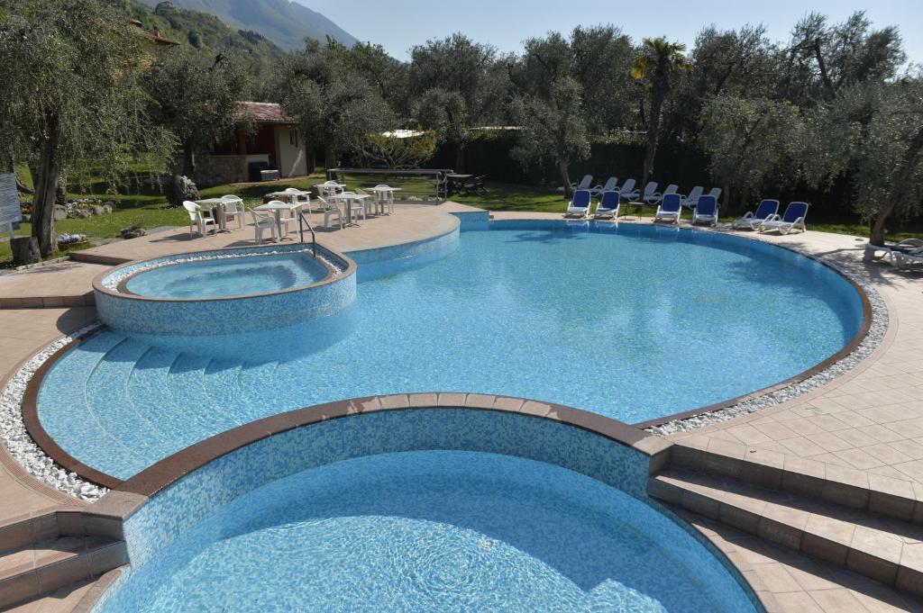 una gran piscina con sillas y una mesa en Hotel Villa Florida en Malcesine