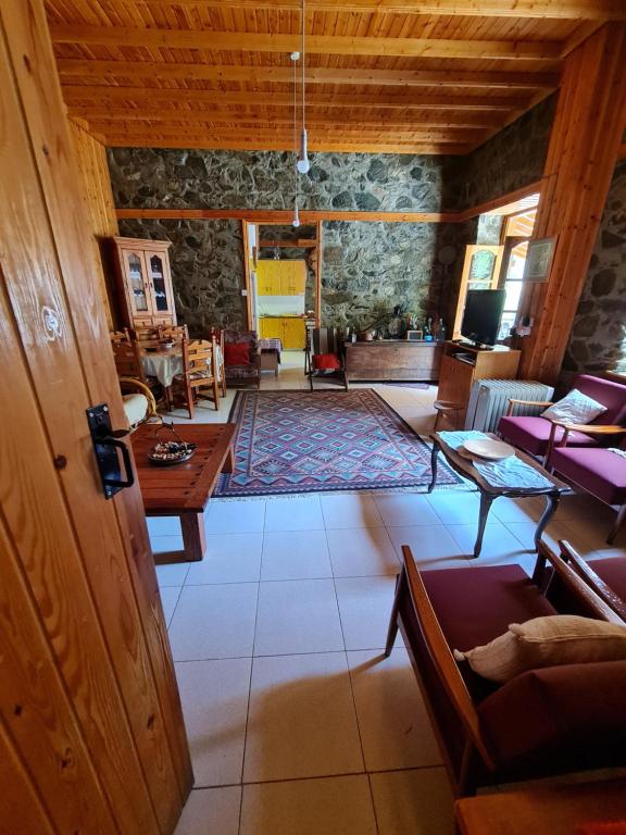 ein großes Wohnzimmer mit einer Steinmauer in der Unterkunft Elpiniki's Old House in Kalopanagiotis