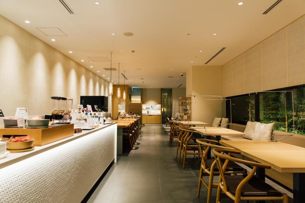 a restaurant with tables and chairs and a bar at Kanazawa Tokyu Hotel in Kanazawa