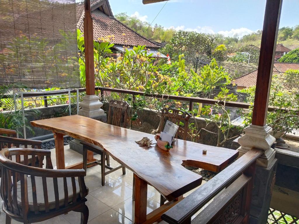 a wooden table and a chair on a balcony at Bagus Homestay in Padangbai