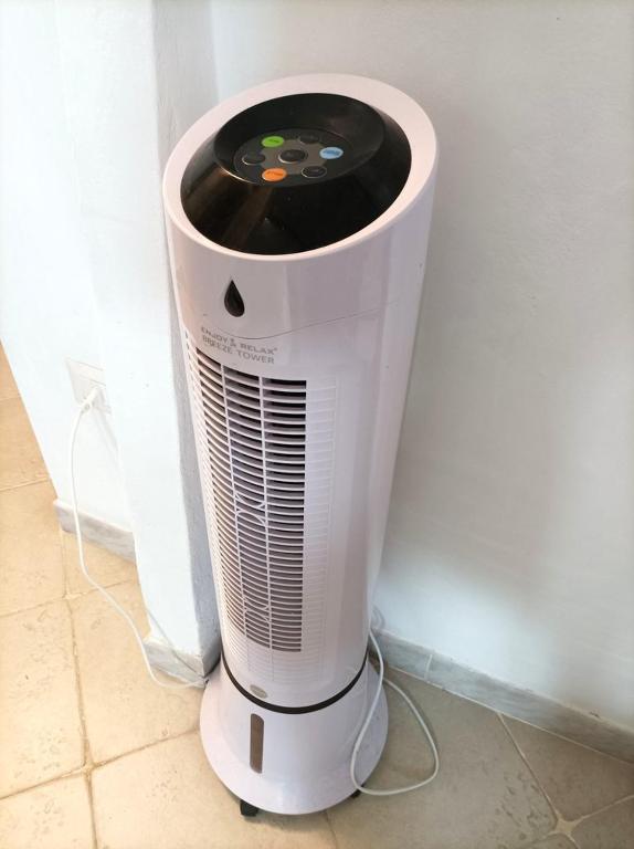a white heater sitting on the floor next to a wall at Sardinia Yellow House in Solanas
