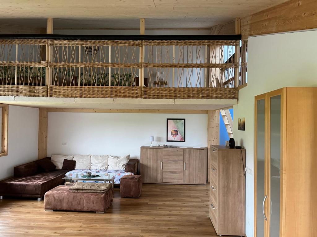 a living room with a loft bed and a couch at Ferienwohnung Ballon im Allgäu in Lechbruck