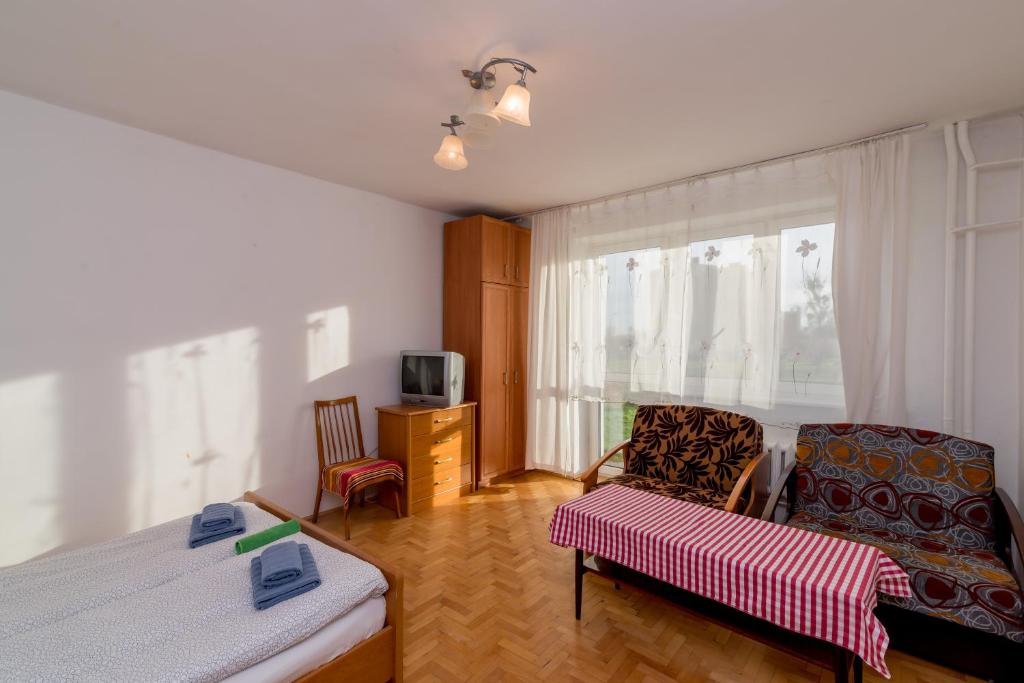 グダニスクにあるRooms in the centerのベッド、ソファ、テレビが備わる客室です。