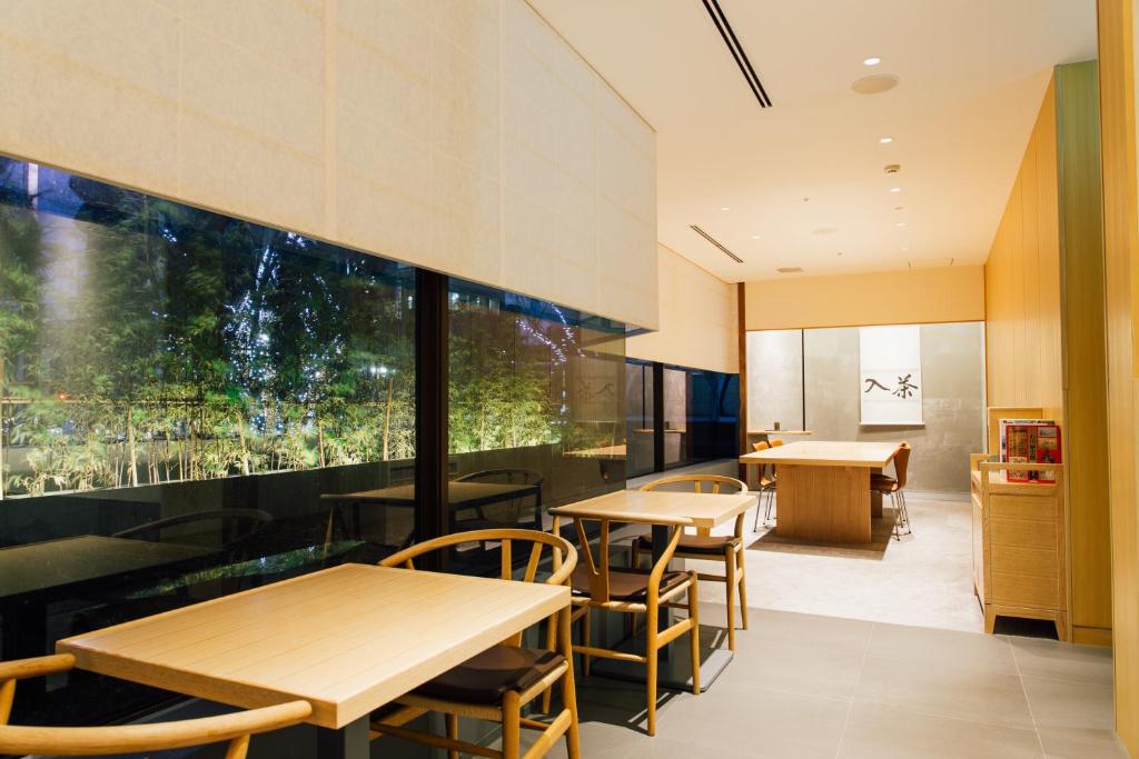 a restaurant with tables and chairs and a large window at Kanazawa Tokyu Hotel in Kanazawa