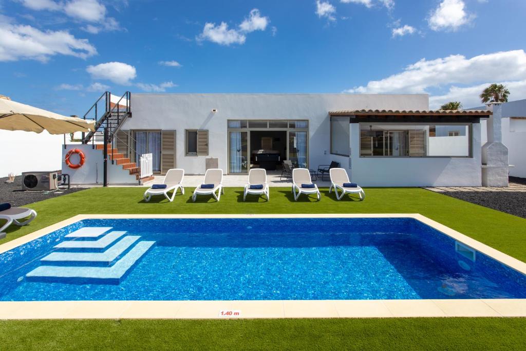 a villa with a swimming pool and a house at Luxury Villa Perla in Caleta De Fuste