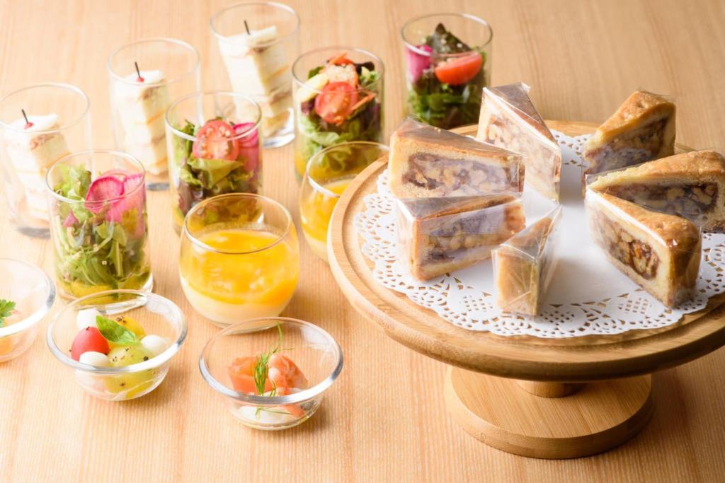 a table with a plate of sandwiches and glasses of wine at Kanazawa Tokyu Hotel in Kanazawa