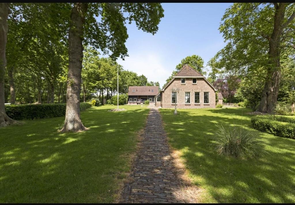 un camino de piedra que conduce a una casa en un campo en Appartement Oosteinde, en Ruinerwold