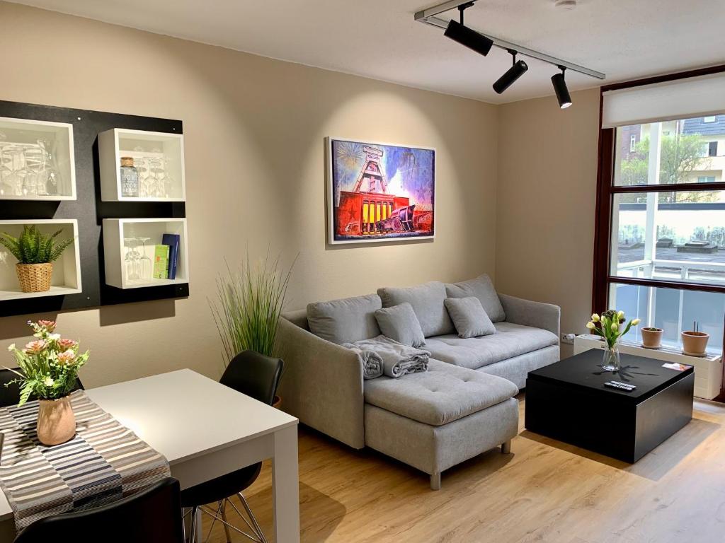 a living room with a couch and a table at Kleiner Koenig - Appartement im Stadtzentrum in Bochum