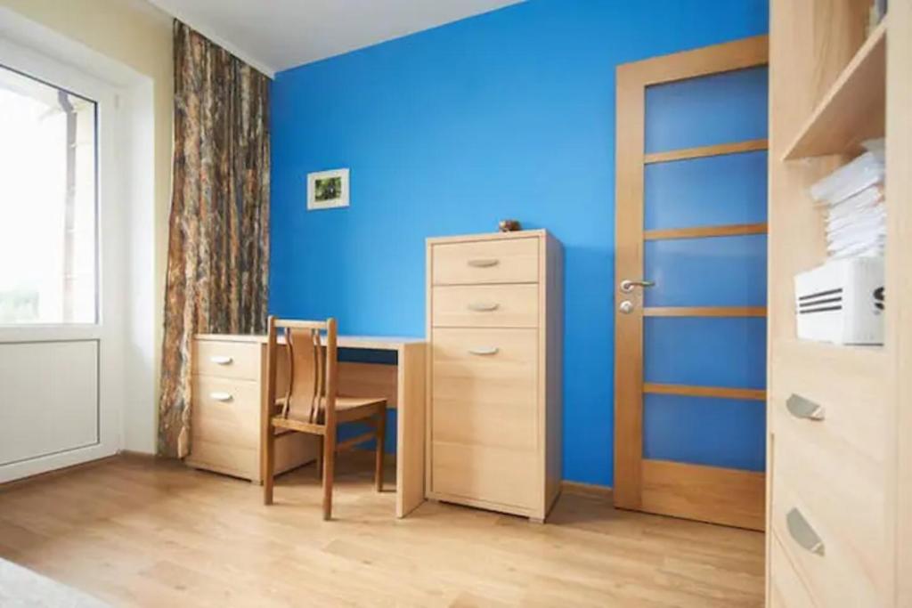a bedroom with blue walls and a desk and a chair at Cozy private room in a three room apartment Free parking Feel like at home in Vilnius