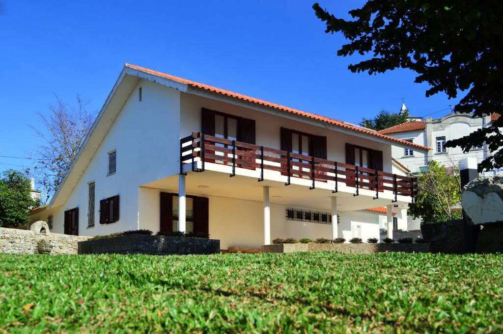 ein weißes Haus mit Balkon auf einem Hof in der Unterkunft Casa São Pedro in Caminha