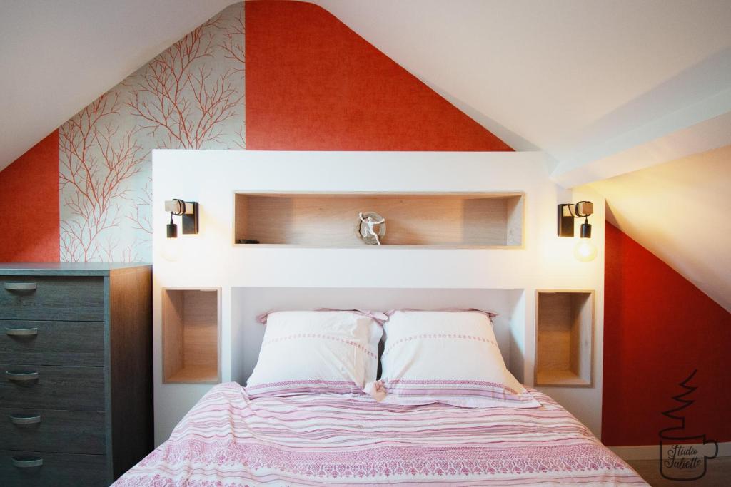 a bedroom with a bed with a red wall at Studio Juliette in Stavelot