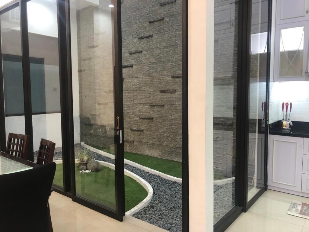 um quarto com portas de vidro deslizantes e um jardim exterior em New 3br The Green Home em Kepiting-kidul