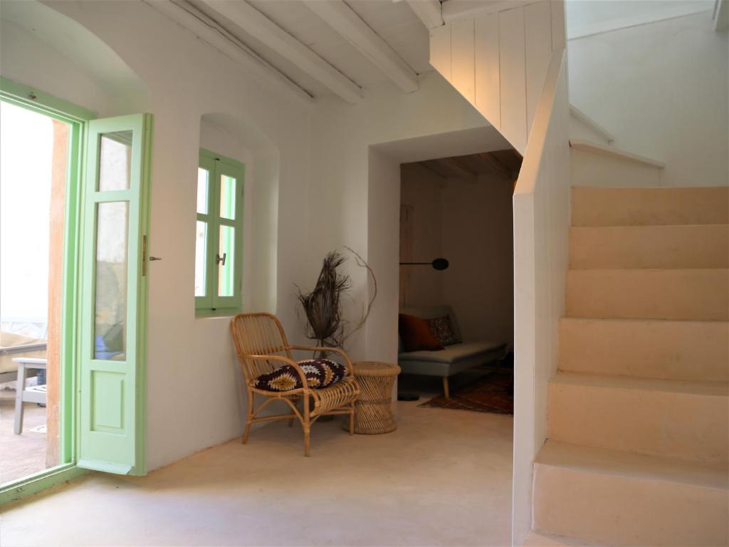 a room with stairs and a chair and a table at Peaceful 2 bedroom heritage vacation house in Nikiá