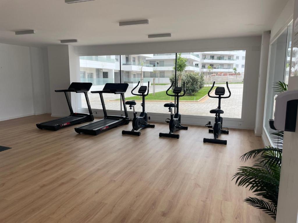 un gimnasio con una fila de cintas de correr y bicicletas estáticas en Brand new apartment with gym&rooftop pool., en Marbella