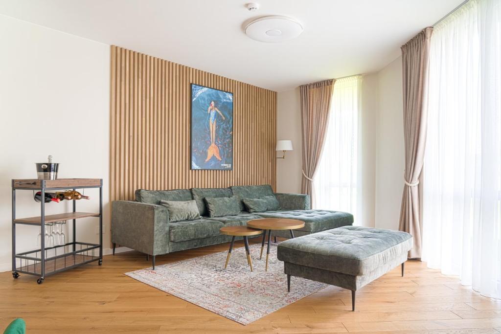 a living room with a green couch and a table at SimSim Apartamentai in Šventoji