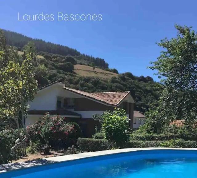 una casa con una montaña en el fondo con una piscina en Casa de los Belgas, en Frama