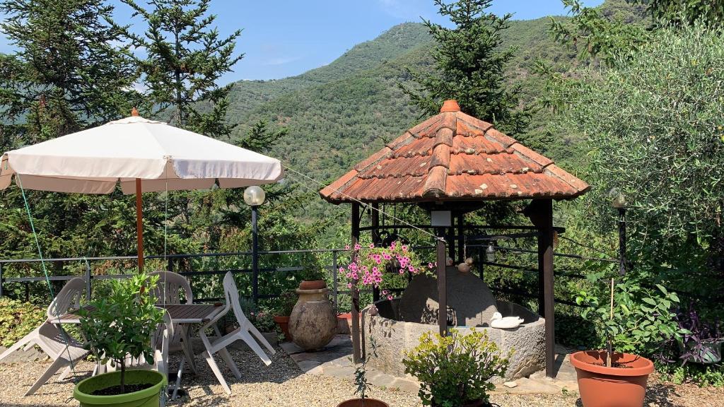 altana ze stołem, krzesłami i parasolem w obiekcie Antica Macina - “La Taverna” w mieście Rocchetta Nervina