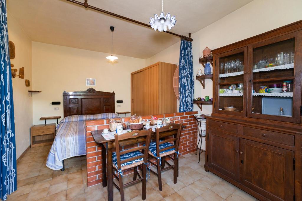 sypialnia z łóżkiem, stołem i krzesłami w obiekcie Antica Macina - “La Taverna” w mieście Rocchetta Nervina