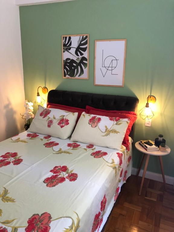 um quarto com uma cama com flores vermelhas em Apartamento Centro Histórico de Petrópolis 200Mbps de internet em Petrópolis