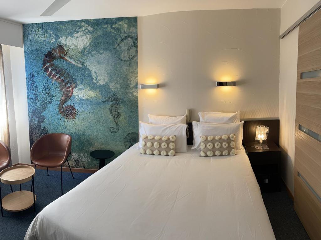 Postel nebo postele na pokoji v ubytování Hôtel Neptune