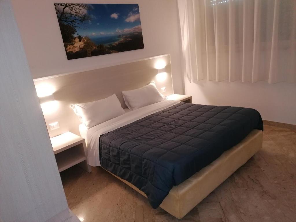 a bedroom with a large bed with two night stands at Zibibbo Beach Apartments - Trapani in Trapani