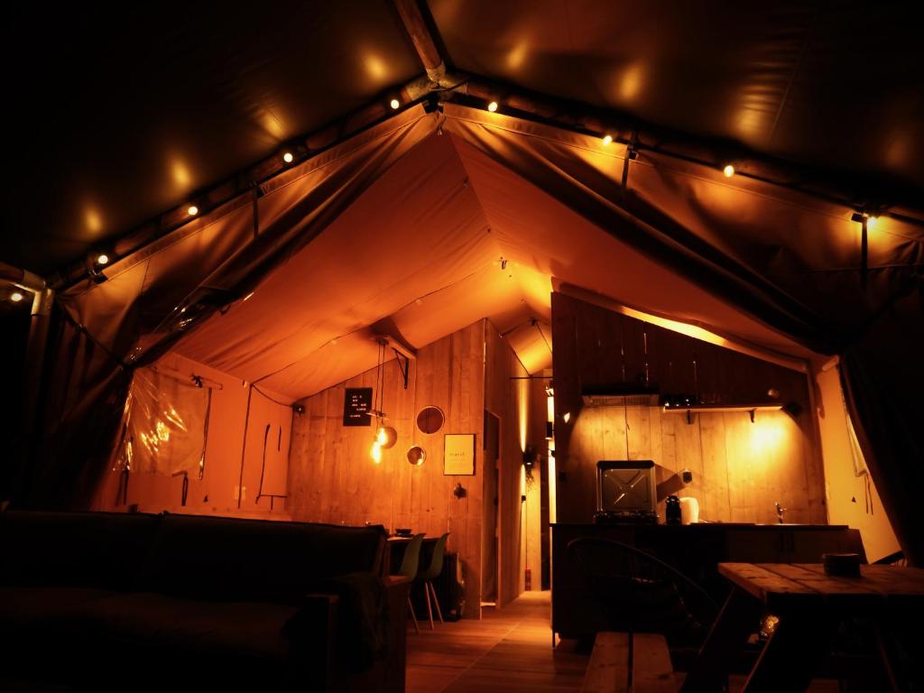 a room with a ceiling with lights on it at Glamped - Luxe camping in Westkapelle