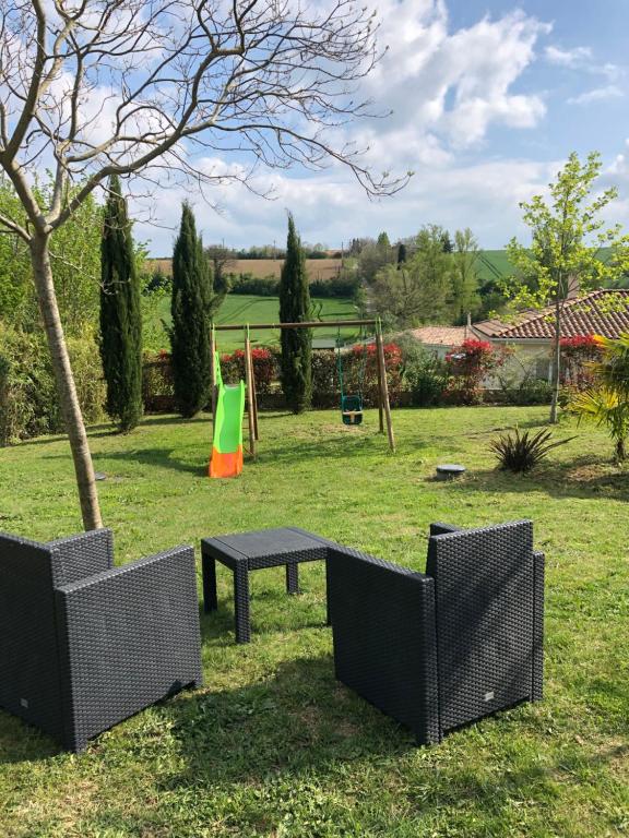 un parque con mesa de picnic y parque infantil en Suite indépendante au cœur d’un jardin arboré., en Montaut