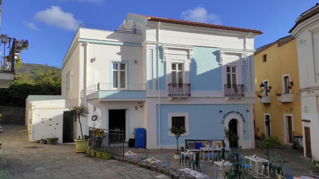 a white house with tables and chairs in front of it at Suitetti Camere&Relax in San Nicola Arcella