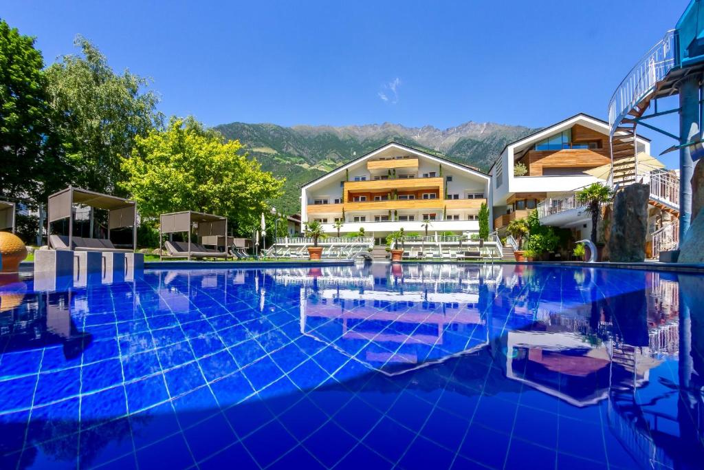 una gran piscina frente a algunos edificios en Familien-Wellness Residence Tyrol, en Naturno