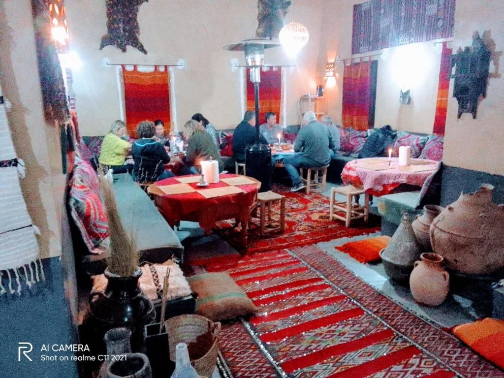 Kasbah Citoyenne في Agoudal: مجموعة من الناس يجلسون على الطاولات في الغرفة