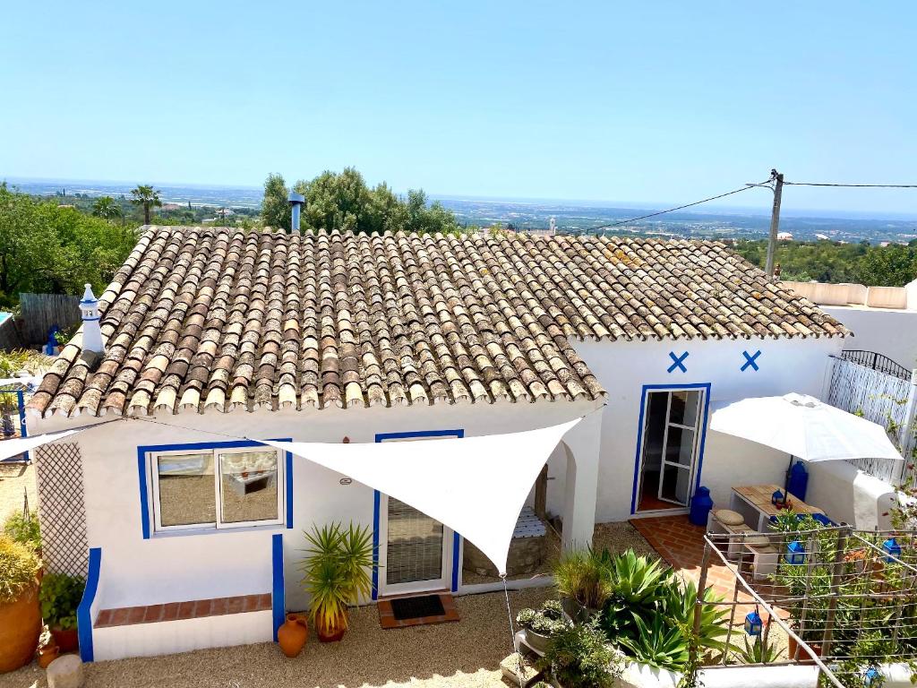 a white house with a brown roof at Casa da Aldeia in Santa Bárbara de Nexe