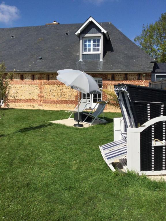 un parasol blanc assis dans la cour d'une maison dans l'établissement Chambre & Caux, à Thiergeville