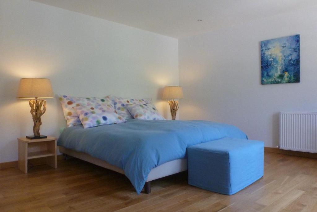 a bedroom with a blue bed and two lamps at Entre Terre et Ciel in Rémuzat