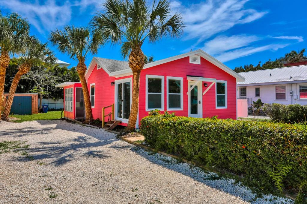 a red house with palm trees in front of it at Almost Heaven in Bradenton Beach