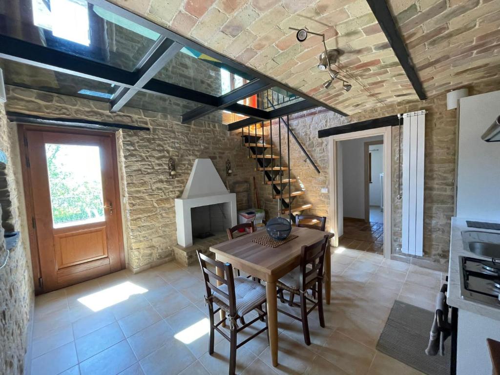 jadalnia z drewnianym stołem i ceglaną ścianą w obiekcie agriturismo borgo del ginepro w mieście Castiglione Messer Raimondo