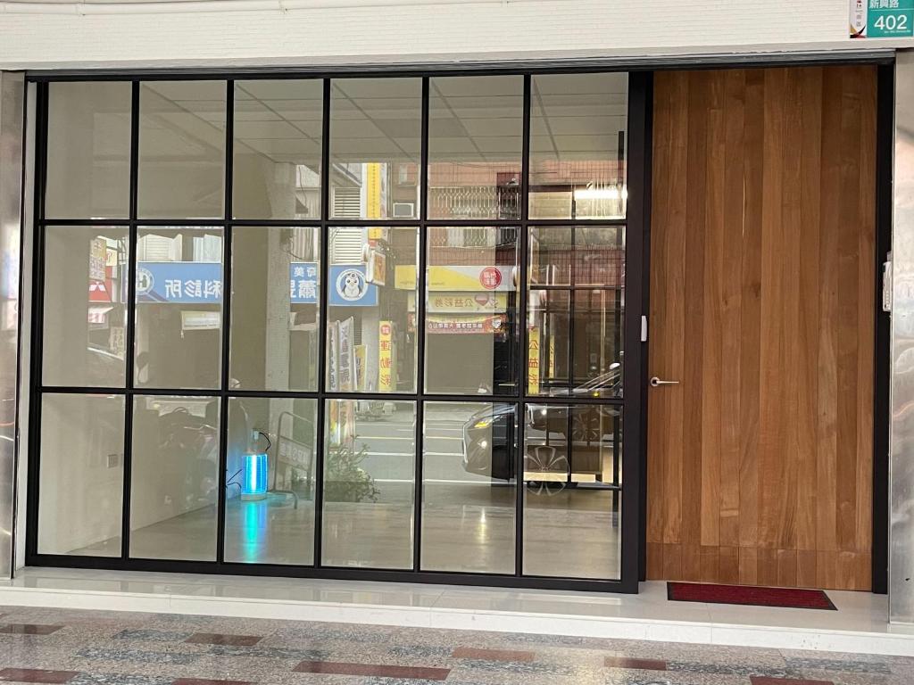 a building with glass windows and a wooden door at Kyushu Homestay in Tainan