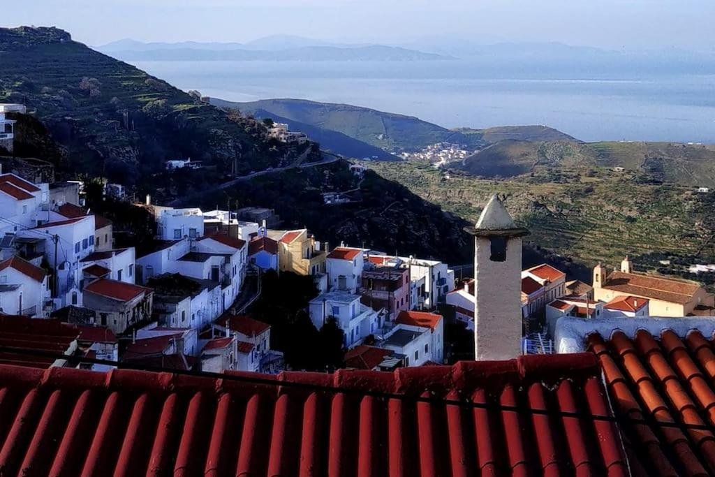 a view of a town with white buildings and the ocean at The house of grandma Zinios in Ioulida