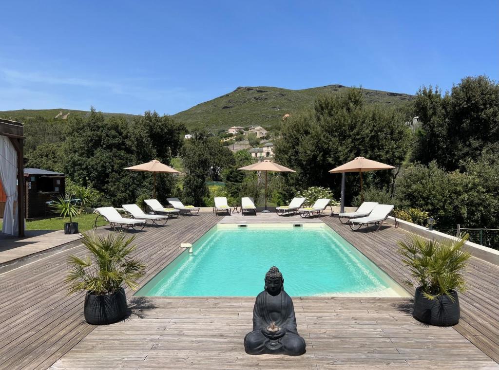 una persona está sentada en meditación cerca de una piscina en Les 5 Arches, en Sisco