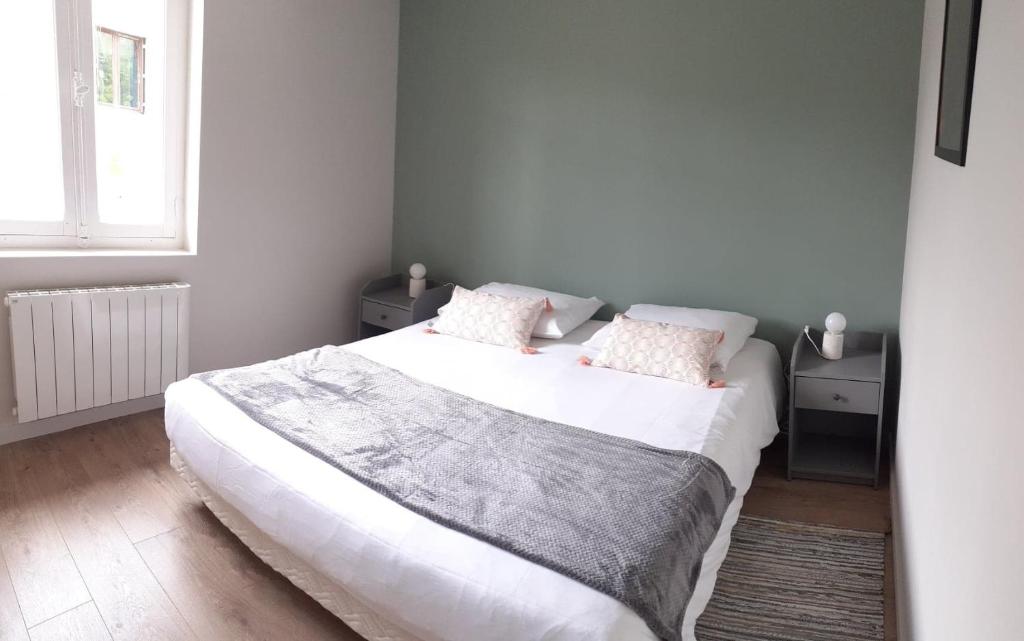 um quarto com uma grande cama branca e 2 almofadas em Le Refuge du Cele em Cabrerets