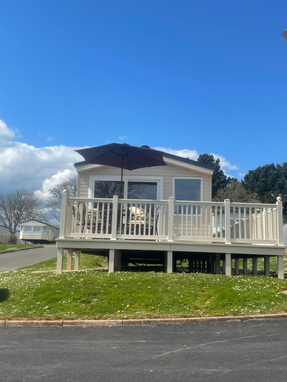 a house with an umbrella on the front porch at B23 in Goodrington