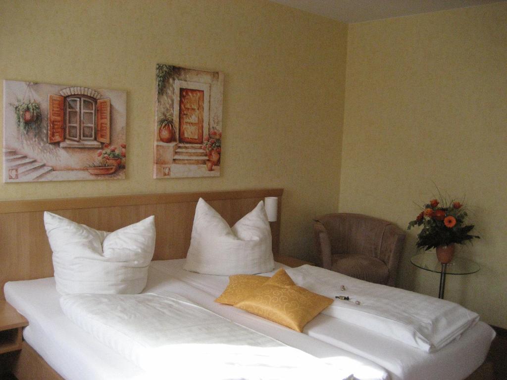 a bed with white sheets and pillows in a room at Altstadthotel Schex in Altötting